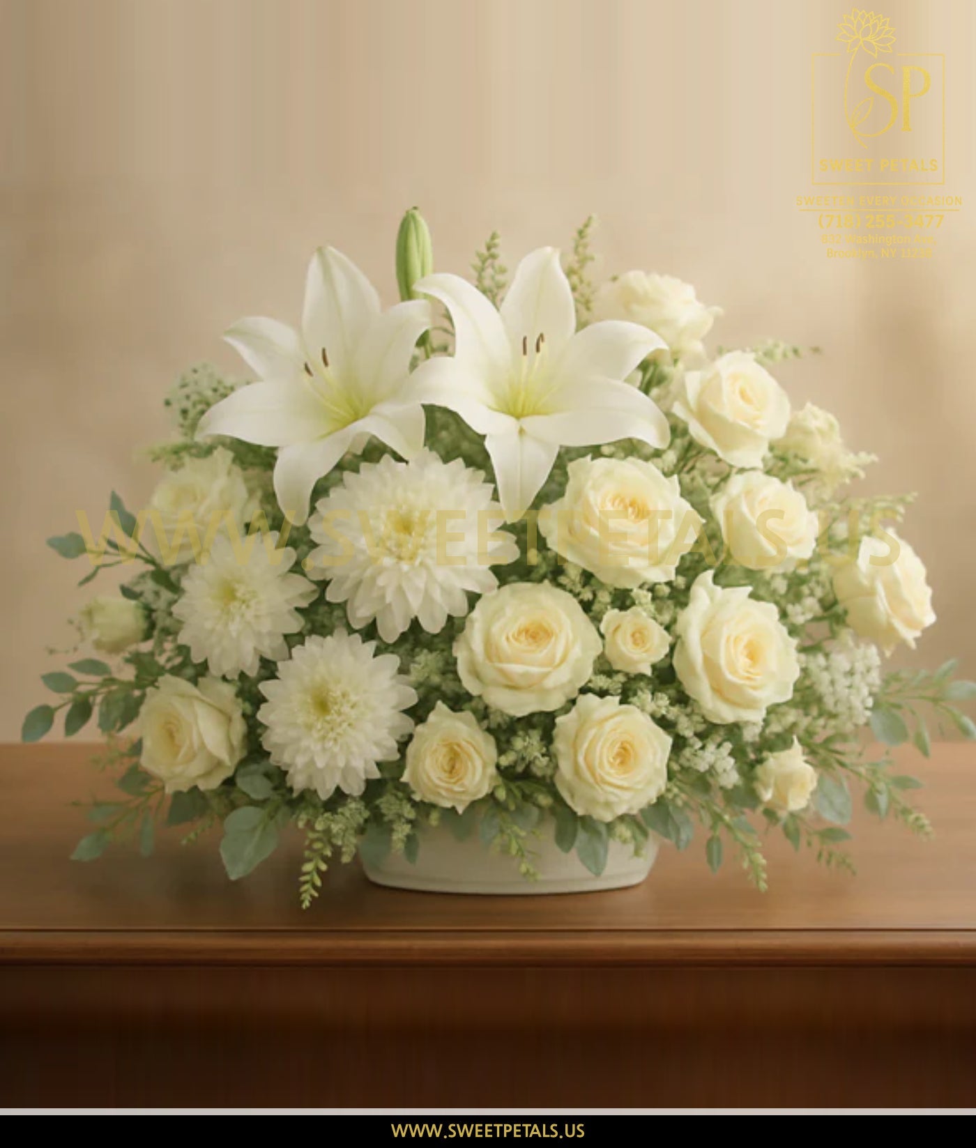 Bouquet of white flowers in a vase on a wooden surface with a beige background.
